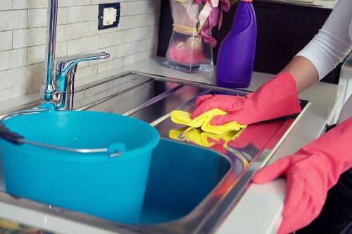 Cleaner maintaining a tidy kitchen and living space in NW11
